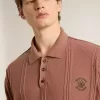 Baksteenkleurige herenpolo met geborduurd logo.