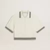 Dames polo shirt in cropped model van versleten wit katoen met blauwe ribboorden