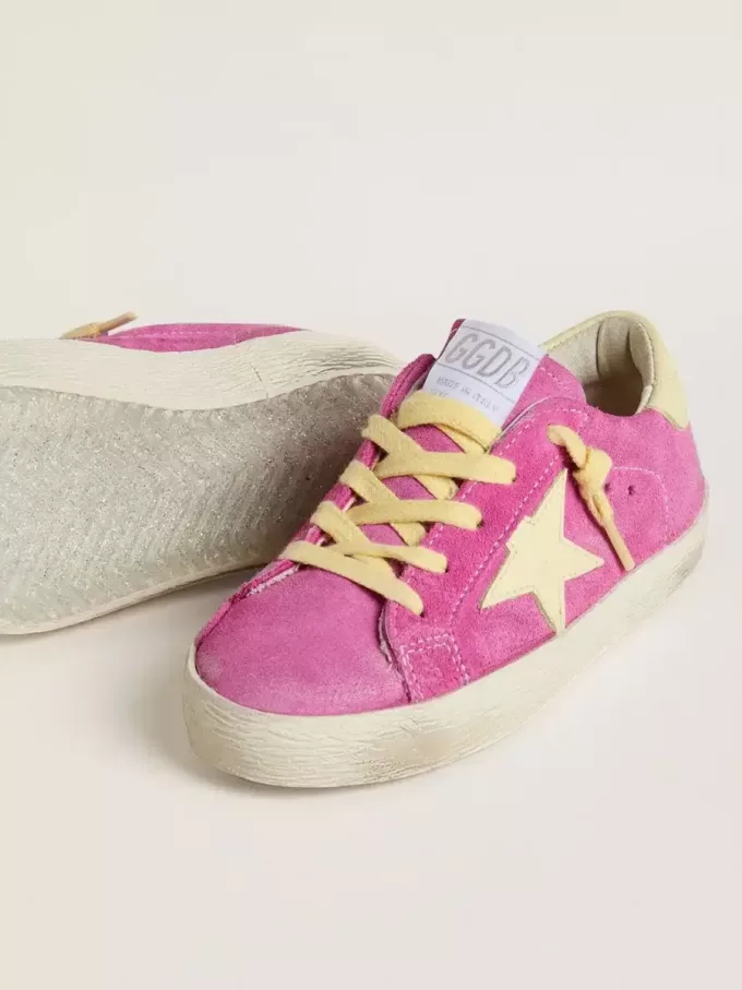 Junior Super-Star in roze suède met lichtgele ster en hiellip.
