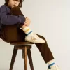 Junior Super-Star van nappaleer met een beige ster en blauwe hiellip.