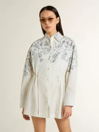 Korte shirtjurk voor dames van wit gestreept katoen met een blauwe maritieme print.