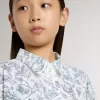 Meisjesshirtjurk van wit katoenen canvas met een blauwe nautische print en witte biezen.