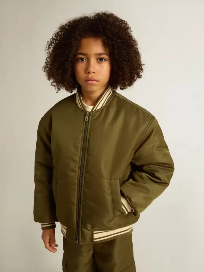 Militairgroen nylon bomberjack voor kinderen met opschrift op de rug.