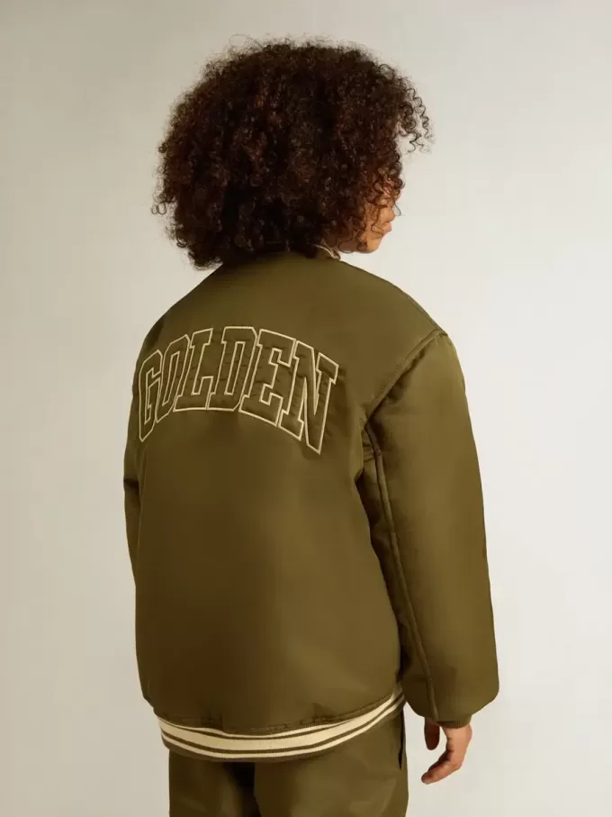 Militairgroen nylon bomberjack voor kinderen met opschrift op de rug.