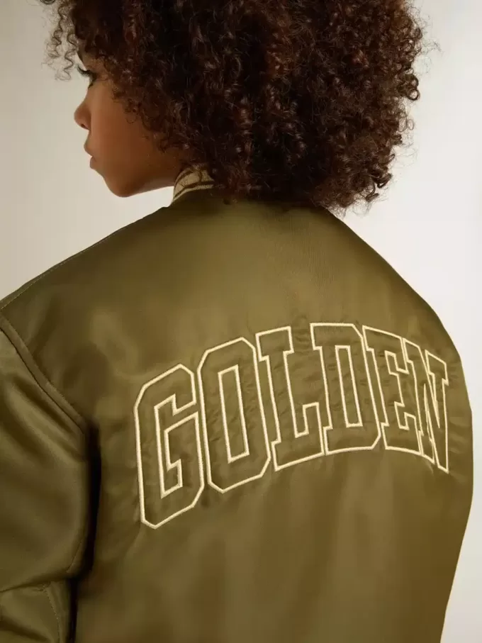 Militairgroen nylon bomberjack voor kinderen met opschrift op de rug.