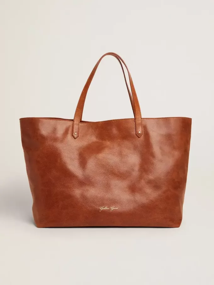 Pasadena-tas in glanzend, gehamerd leer in tan-kleur met gouden logo op de voorkant