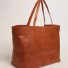 Pasadena-tas in glanzend, gehamerd leer in tan-kleur met gouden logo op de voorkant