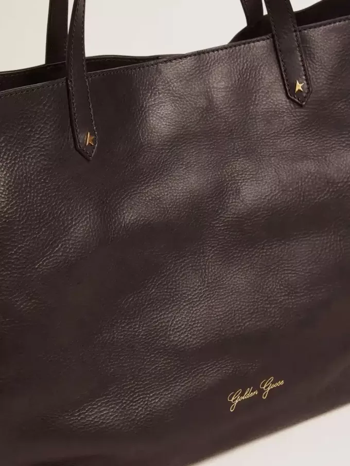 Pasadena-tas in zwart gehamerd leer met gouden logo op de voorkant