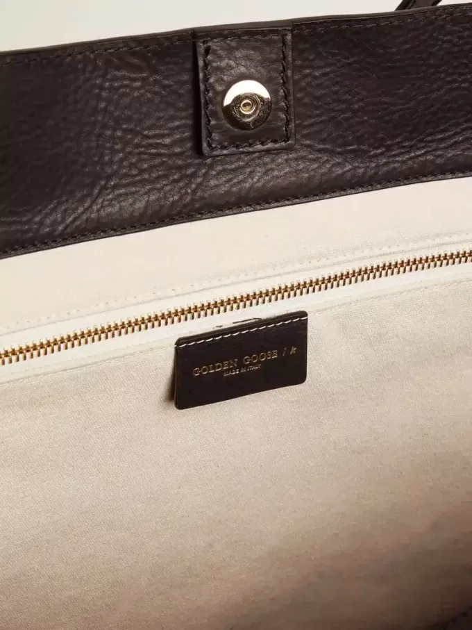 Pasadena-tas in zwart gehamerd leer met gouden logo op de voorkant