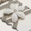 Skin “Vintage” zwart-beige gestreepte veters met bloemvormig bedeltje