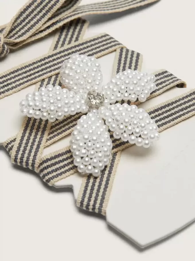 Skin “Vintage” zwart-beige gestreepte veters met bloemvormig bedeltje