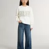 Wit sweatshirt voor meisjes met veelkleurige gouden letters op de voorkant.