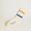 Witte kindersokken met distressed details en tweekleurige felblauwe en mosterdkleurige strepen.