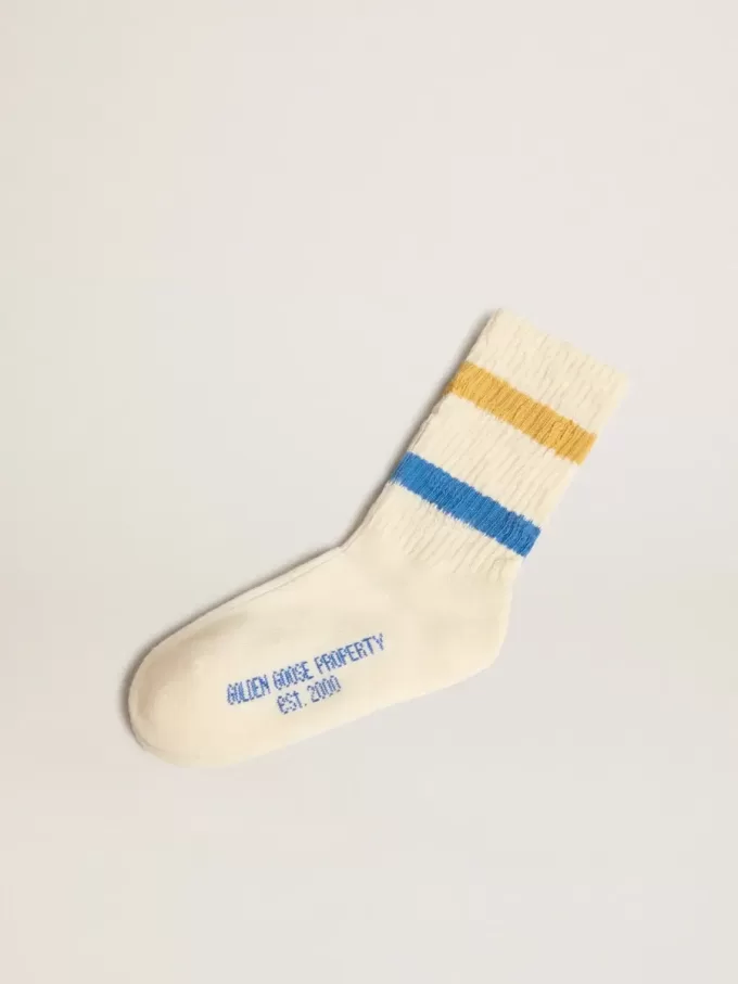 Witte kindersokken met distressed details en tweekleurige felblauwe en mosterdkleurige strepen.