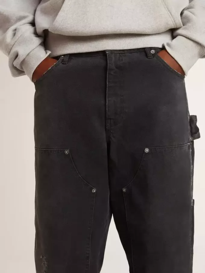 Zwarte katoenen herenjeans met versleten effect en patches aan de voorkant